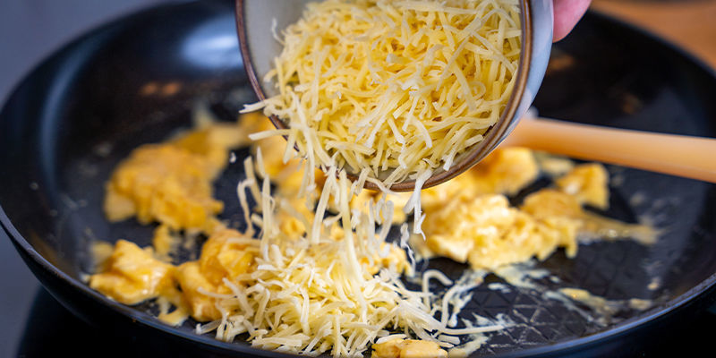 Sprinkle 2 Tbsp Of Your Favourite Grated Cheese On Top Of The Eggs And Allow It To Melt.